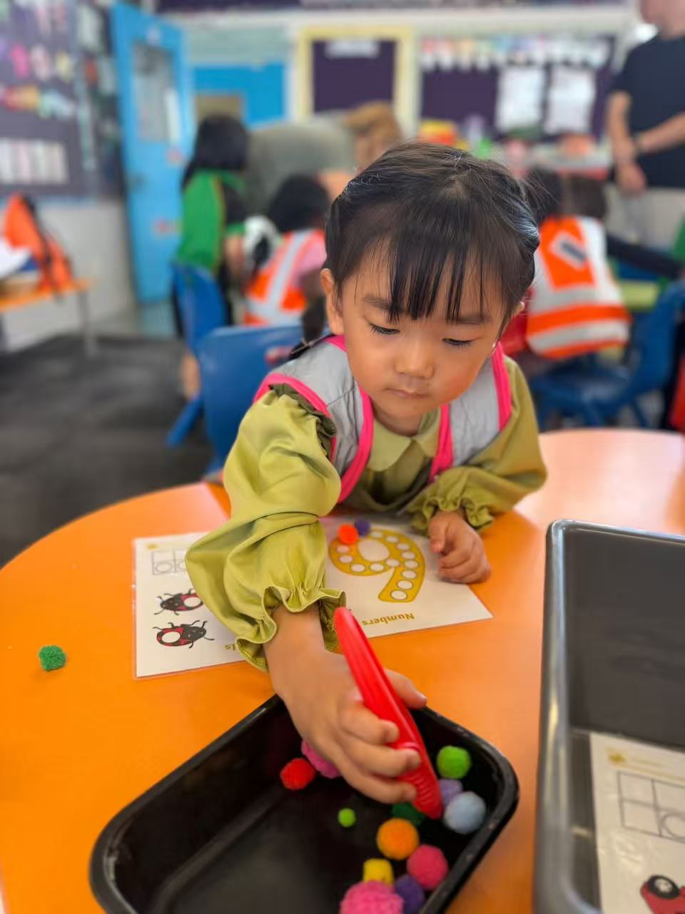Child using tongs during a fine motor activity