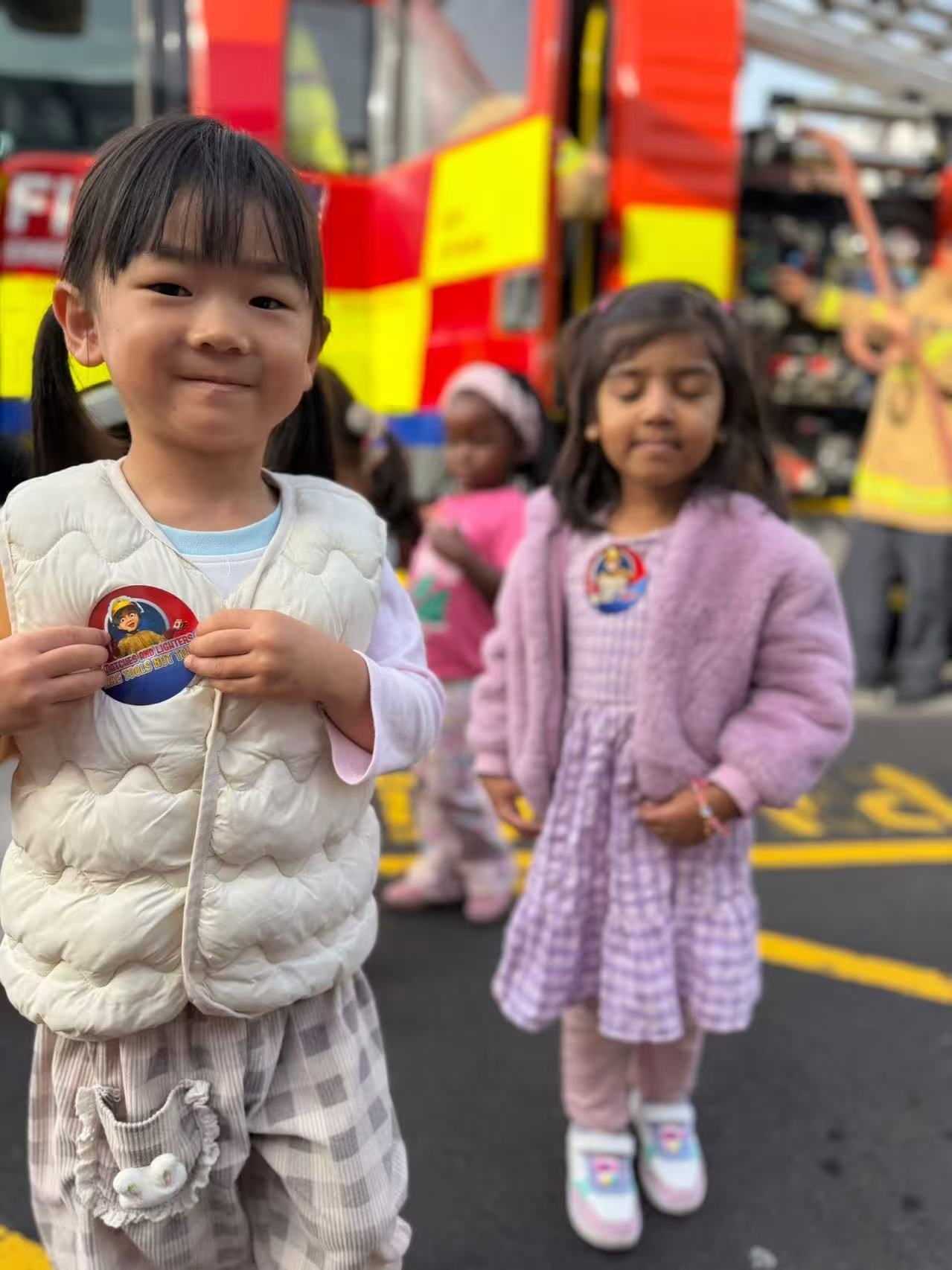 Child smiling in front of a fire truck